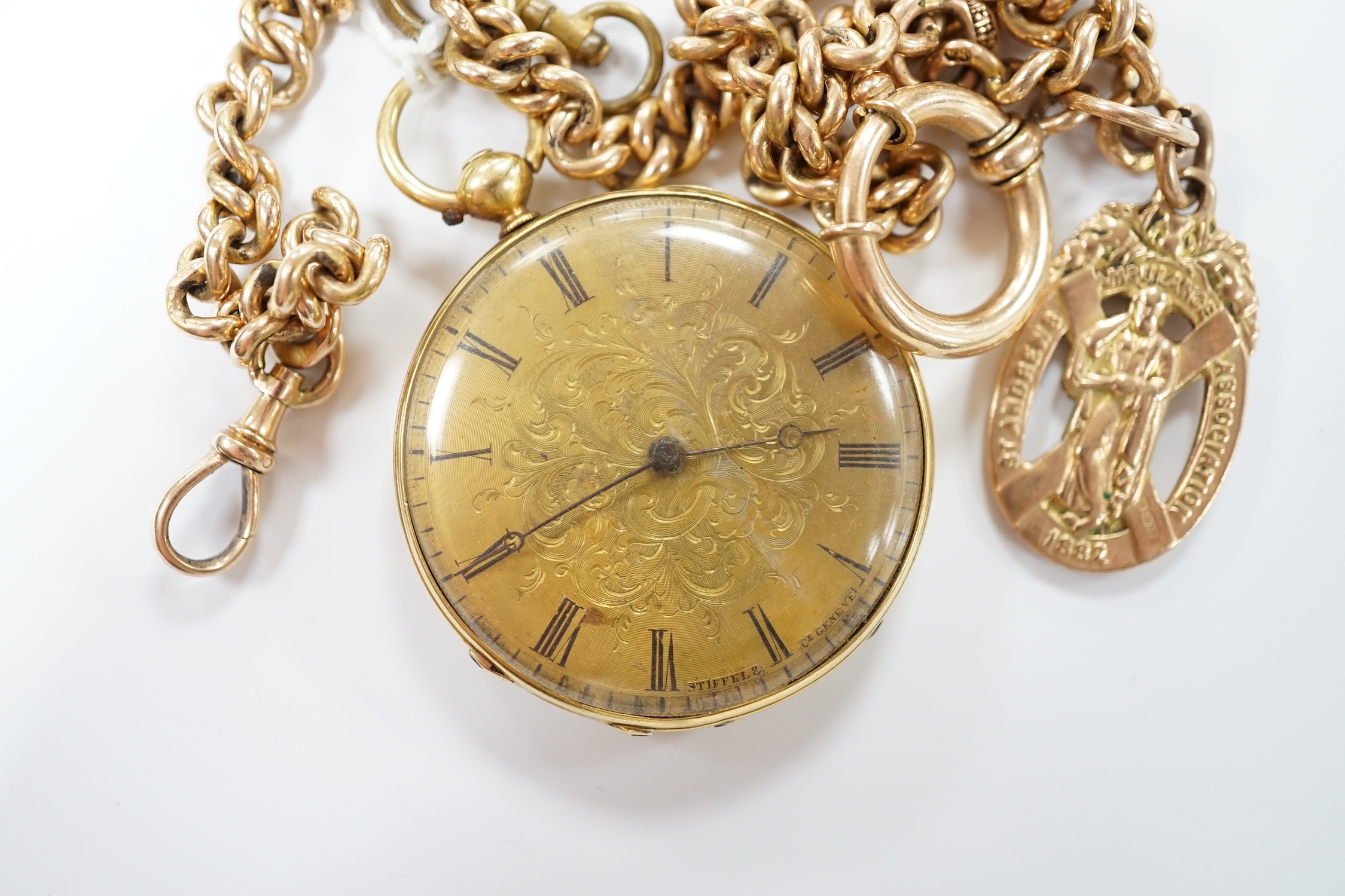 An 18k open face fob watch, with Roman dial, gross weight 38.5 grams, with key, together with a 9ct albert hung with a 9ct gold St. Andres Ambulance Association charm, gross weight 24.2 grams.
